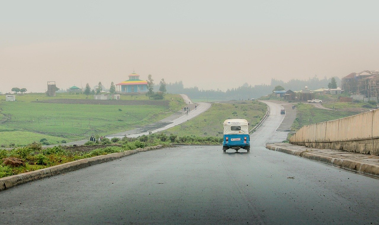 Dreirad, Straße, Hügel, nasse Straße, Straße, Fahrspur, Bürgersteig, Allee, Fahrzeug, Transport, Addis Abeba, Äthiopien, orthodoxe Kirche, Afrika, Regen, regnerisch, regnerisches Wetter, Landschaft, Natur, Felder, Addis Abeba, Addis Abeba, Addis Abeba, Äthiopien, Äthiopien, Äth