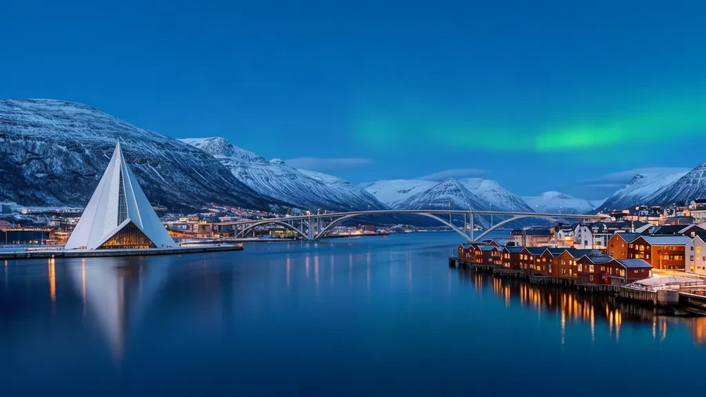 Tromsø, lungomare norvegese al crepuscolo con la Cattedrale Artica e il Ponte di Tromsø incorniciati dalle montagne innevate del fiordo