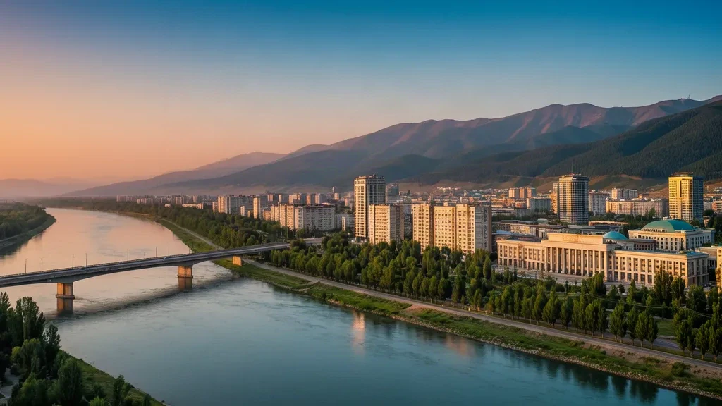 Oskemen skyline along the Irtysh River in East Kazakhstan at golden hour, with Altai foothills and a wide embankment