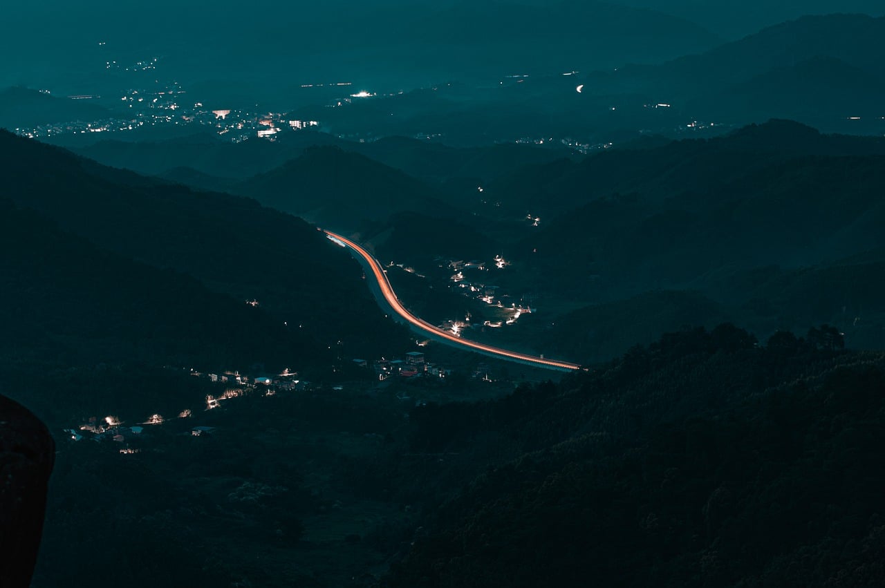 paisaje nocturno, montañas, naturaleza, autopista, estelas de luz, paisaje de noche, zona montañosa, luces de la ciudad, luces de la carretera, toma panorámica, noche tranquila, vista lejana, paisaje silencioso, larga exposición, silueta de montañas, pueblo pequeño, atmósfera tranquila, zona rural