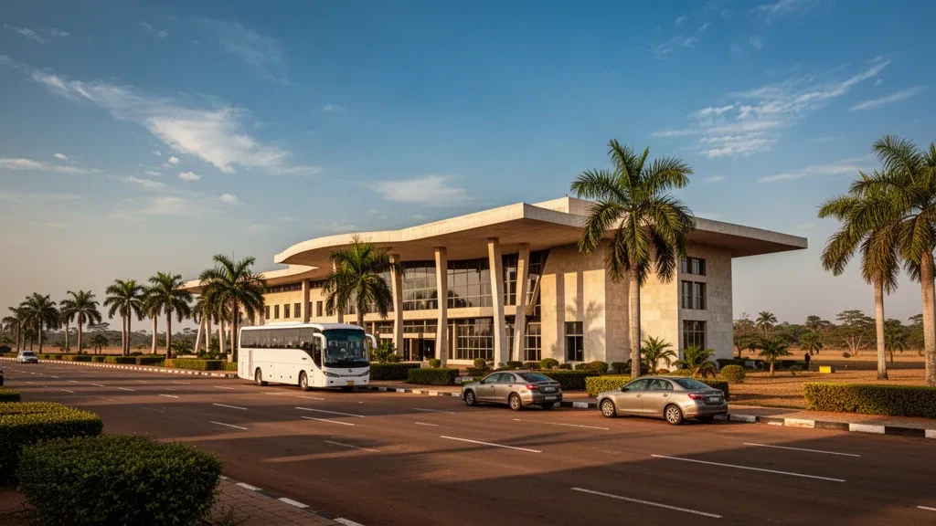 Low-rise terminal and palm-lined forecourt at Yamoussoukro International Airport in Côte d'Ivoire during warm late afternoon light