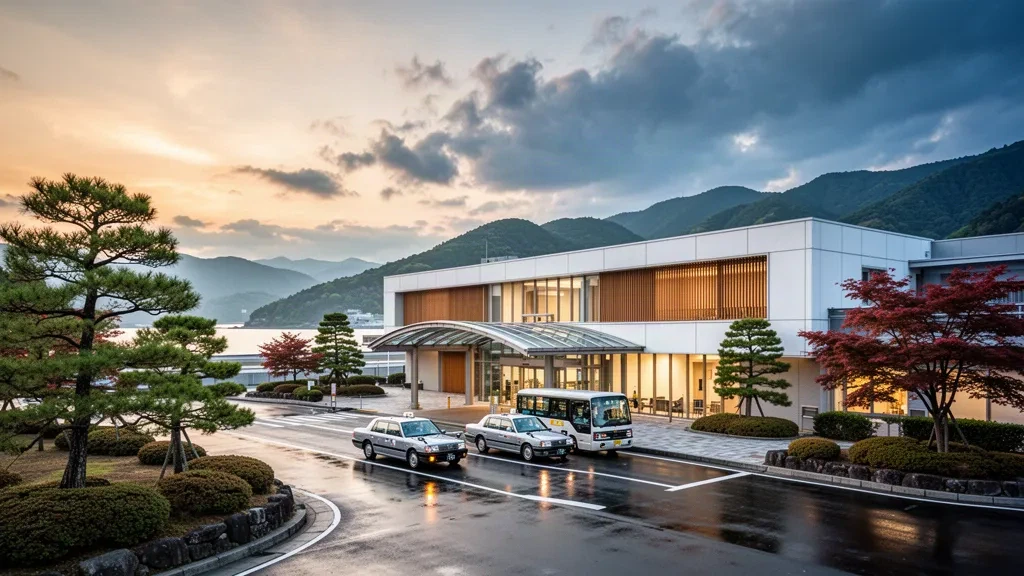 Moderne Glasfassade des Terminals am Flughafen Izumo Enmusubi in Shimane, Japan, die in der Abenddämmerung mit klarer, offener Fläche leuchtet